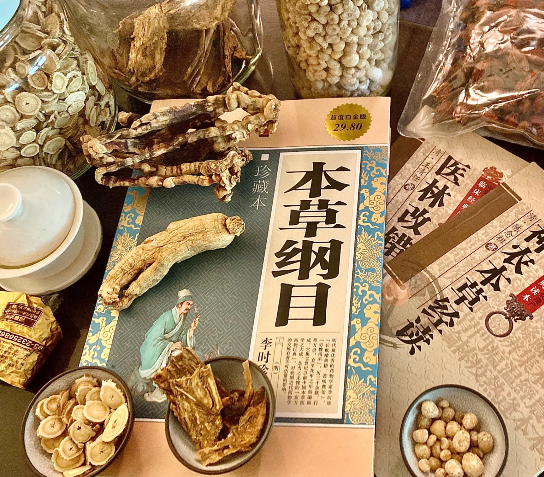 Ben Cao Gang Mu herbal medicine book with raw herbs