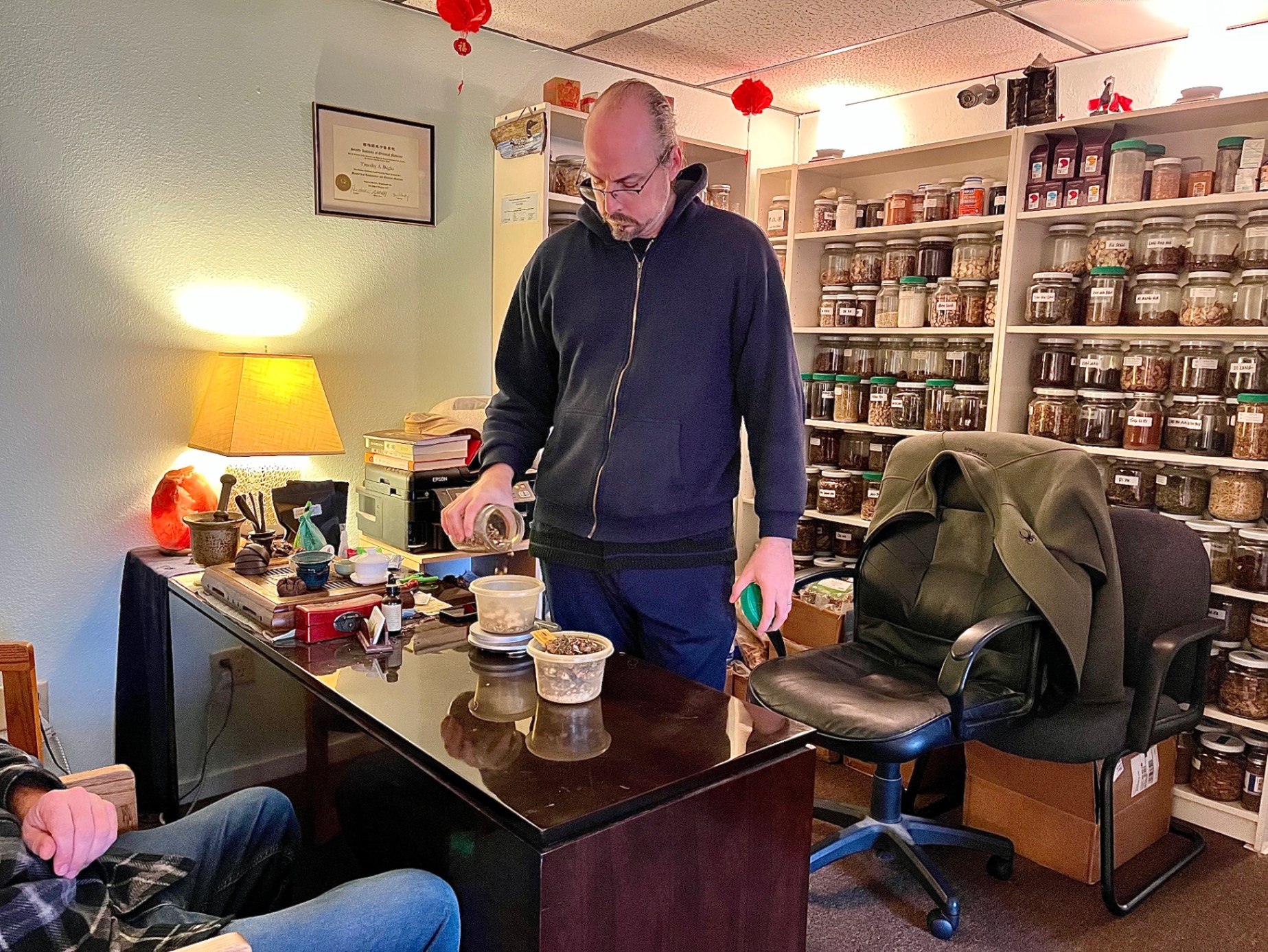 Tim Baglio preparing a Chinese herb formula at the pharmacy desk